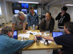 WHOI scientists meeting in the lab to discuss data collected.