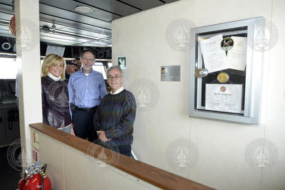 Carol Armstrong, Rob Munier and Mark Abbott with the installed gold medal case.