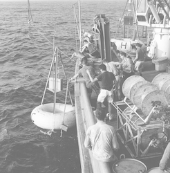 Group putting buoy in the water from the deck of Chain