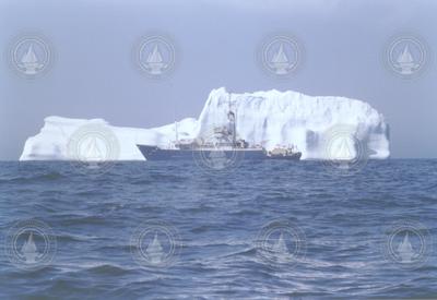 Full view of Knorr, large iceberg in background, color photo