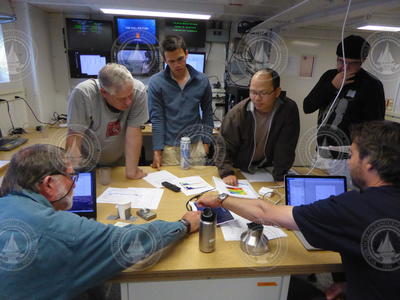 WHOI scientists meeting in the lab to discuss data collected.