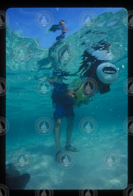 Underwater view of Andrey Scherbina holding REMUS 100.
