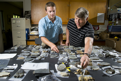 SSF Benjamin Urann looking over rock specimens with Henry Dick.
