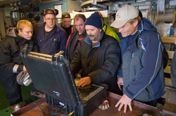 Researchers gather around ROV operator John Bailey.