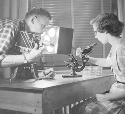 Unidentified man filming Roberta Claire (Eike) Blanchard in Bigelow Lab.