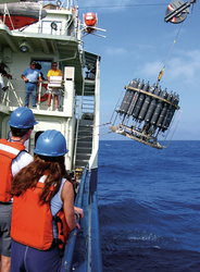 Water sampling rosette with CTD is deployed off R/V Oceanus.