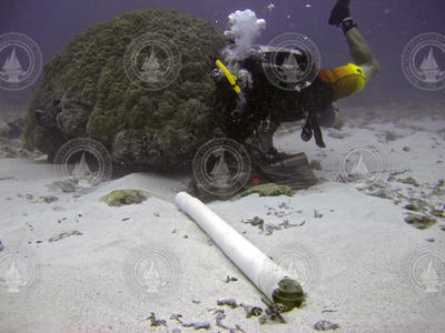 Justin Ossolinski SCUBA diving to collect coral core and associated gear.