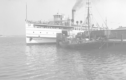 R. B. Stinson tied to dock, Steamship ferry in background