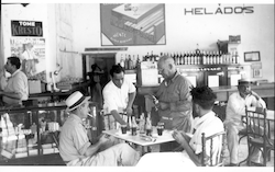Hans Cook on left and H. Mandly, standing, in a restaurant