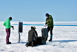 Researchers installing a GPS unit on the Greenland ice sheet.