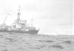 Knorr with large iceberg in background