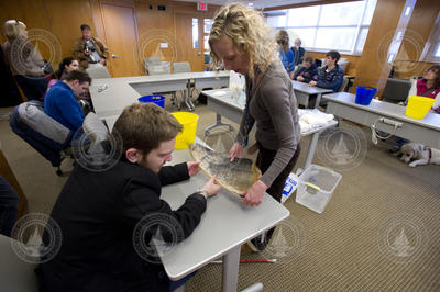 Karen Damelio assisting a student as he examines whale baleen.