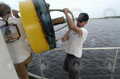 Malcolm Scully and Rocky Geyer move a mooring to a safe location for disassembly.
