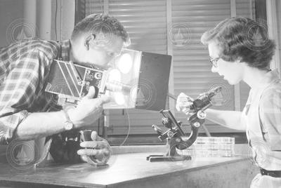 Roberta Claire (Eike) Blanchard in lab with Henry Johnson, filming microscope