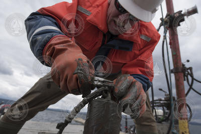 Rob Sohn wrestling with a muddy shackle after retrieving a core.