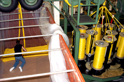 Synthetic rope are flaked into a shipping container.