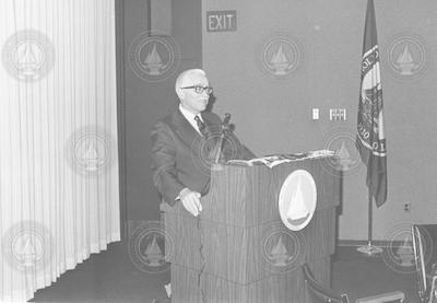 Paul Fye speaking at podium