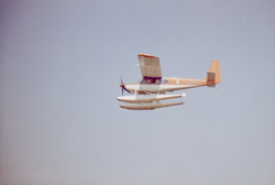 Helio courier in air during pick up trials.