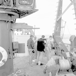 John Beckerle (left) and Stan Bergstrom (2nd to left) with group working on deck of Chain near A