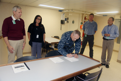 U.S. Navy Commander William Fallier signing the possession transfer paperwork.