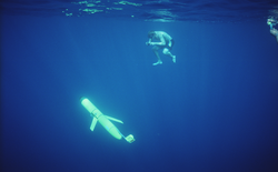 David Sutherland underwater taking photos of a Thermal Glider.