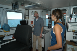 Captain Ken Houtler showing Orianna DeMasi Tioga electronics equipment.