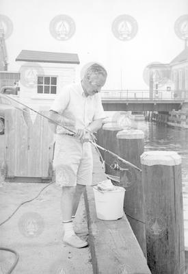 Howard Sanders on dock with fishing pole.
