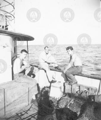 Three men sitting on deck of Mentor