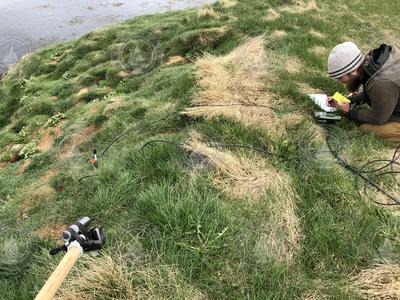 Adam Smith setting up microphones to listen to puffins in Iceland.