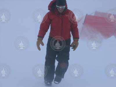 Ali Criscitiello walking across the ice in blowing snow.