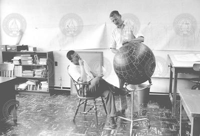 William Metcalf and Rocky Miller looking at globe