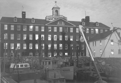 Bigelow Building at dusk, with docked boats and White House in foreground.