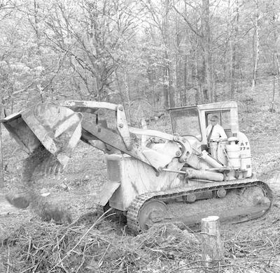 Paul Fye operating bulldozer at Quissett Campus groundbreaking.