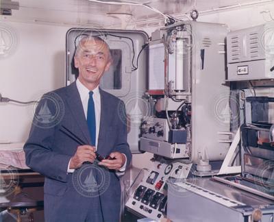 Jacques Cousteau standing in front of equipment