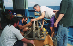 Dan Fornari (purple shorts) preparing a sediment grab sampler.