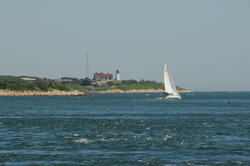 A sailboat passing through Great Harbor in front of Nobska Point.
