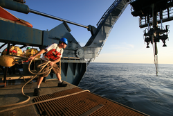 Alvin Tech Anton Zafereo tossing Alvin's tow line off the fantail.