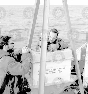 Two unidentified men working with buoy (?) on deck