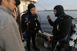 Geyer, Lohmann and Jay Sisson confer after Pat and Jay's dive to locate tripod.