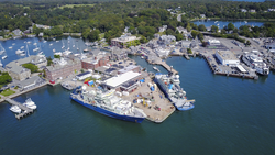 Aerial of Woods Hole village and the WHOI dock with three vessels.