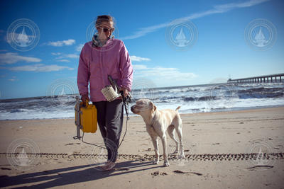 Britt Raubenheimer and her guide dog, Hugger, walking the beach in Duck, NC.