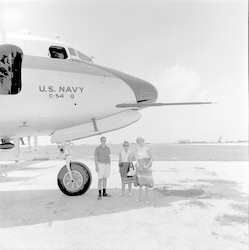 People standing near nose of C54Q aircraft.