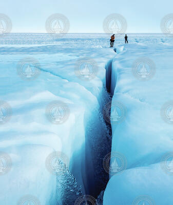 Water flowing into a long icy crevasse in Greenland.