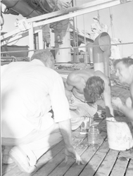 Bill Richardson (left) and Val Worthington (right) looking at sample on deck