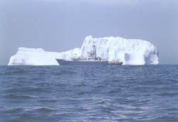 Full view of Knorr, large iceberg in background, color photo