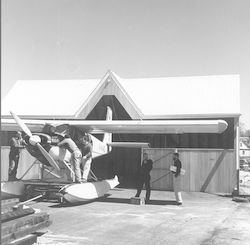 Dyer's Dock Hangar with Helio courier aircraft at doorway.