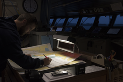 Third mate Mike Singleton filling out the R/V Neil Armstrong engineering log.