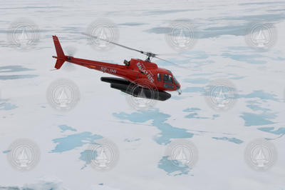 Helicopter in flight over ice.