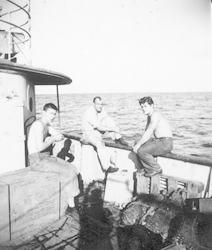 Three men sitting on deck of Mentor