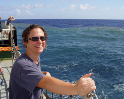 Annette Hynes on R/V Kilo Moana with a Trichodesmium bloom in the background water.